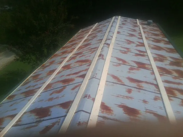 Rusted metal roof panels with new wood purlins before replacement — Storm Damage Roof Repair in Coeymans by Roofing Brothers