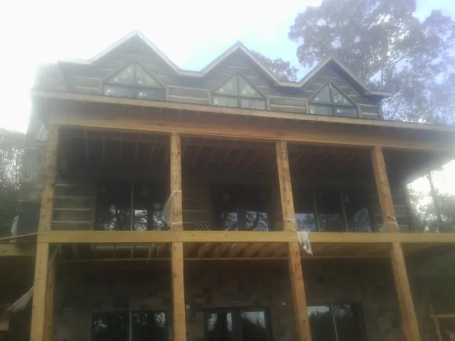 Dormers and porch framing on a large log home under construction — Roof Coating work by our crew in Coeymans