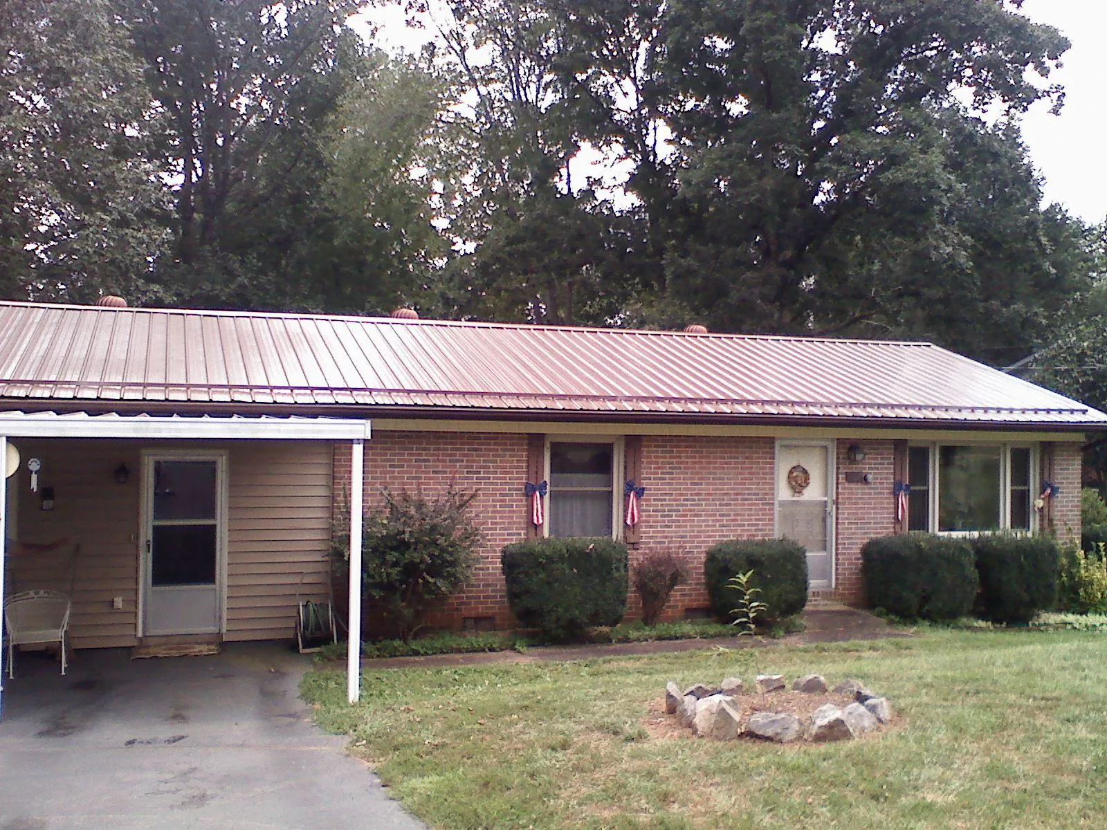 Bronze metal roof and carport on a brick ranch home — Roof Repair work by our crew in Coeymans